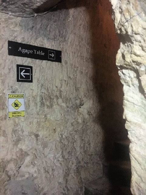 Un cartel señalando el camino a la Mesa del Ágape dentro de las catacumbas del museo Wignacourt.