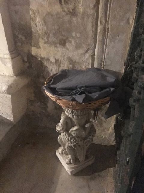 Un cesto sobre un pedestal de piedra con chales para cubrirse en la gruta de San Pablo.